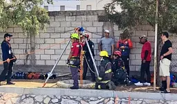 Rescatan con vida a padre e hijo tras caer a pozo en la Interamericana